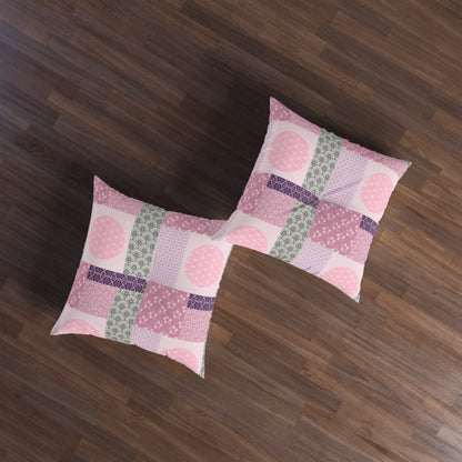 Two square patchwork floor pillows with pink, purple, and green patterns, arranged on a dark brown wooden floor.