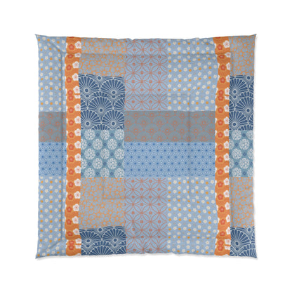 Patchwork quilt with geometric patterns in blue, orange, and gray on a white background