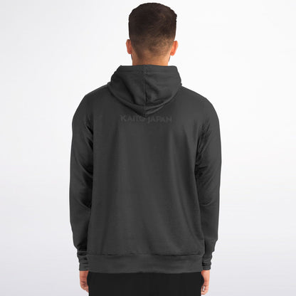 A man viewed from behind wearing a dark charcoal gray hoodie with a subtle tonal 'KAITO JAPAN' logo printed across the upper back, set against a plain white studio background.