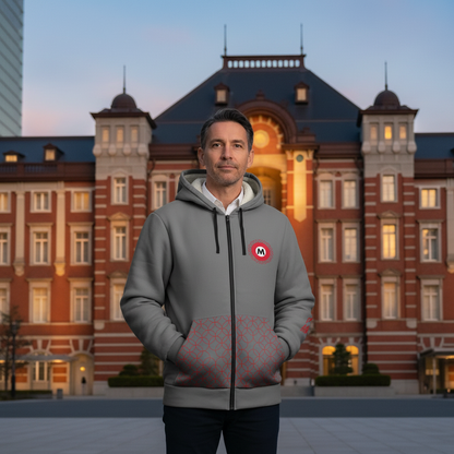 Man wearing a gray hoodie with a logo in front of a large building