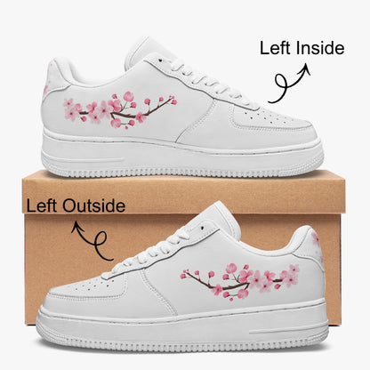 White sneakers with cherry blossom design on a cardboard box