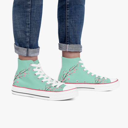 Mint green high-top sneakers with floral design worn with rolled-up jeans on a white background