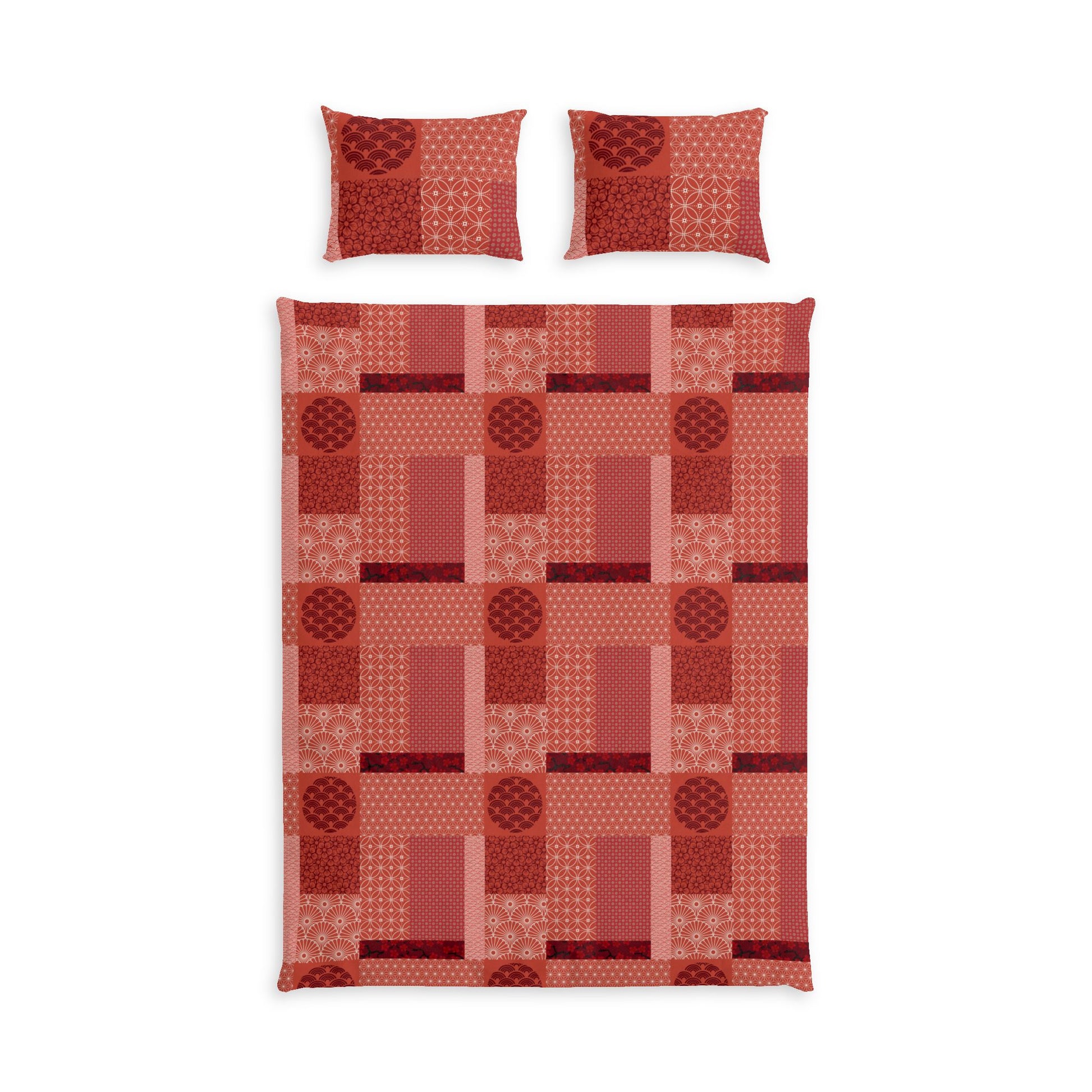 A bedding set featuring a patchwork quilt and two matching pillowcases in shades of red, terracotta, and pink with geometric and circular patterns, displayed on a solid white background.