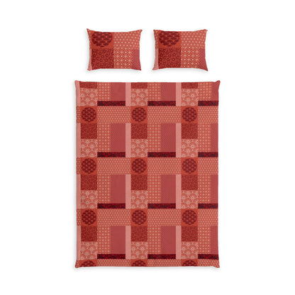 A bedding set featuring a patchwork quilt and two matching pillowcases in shades of red, terracotta, and pink with geometric and circular patterns, displayed on a solid white background.
