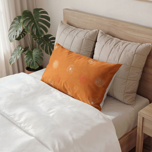 Bed with beige pillows and an orange pillow, wooden headboard, and plant in the background.