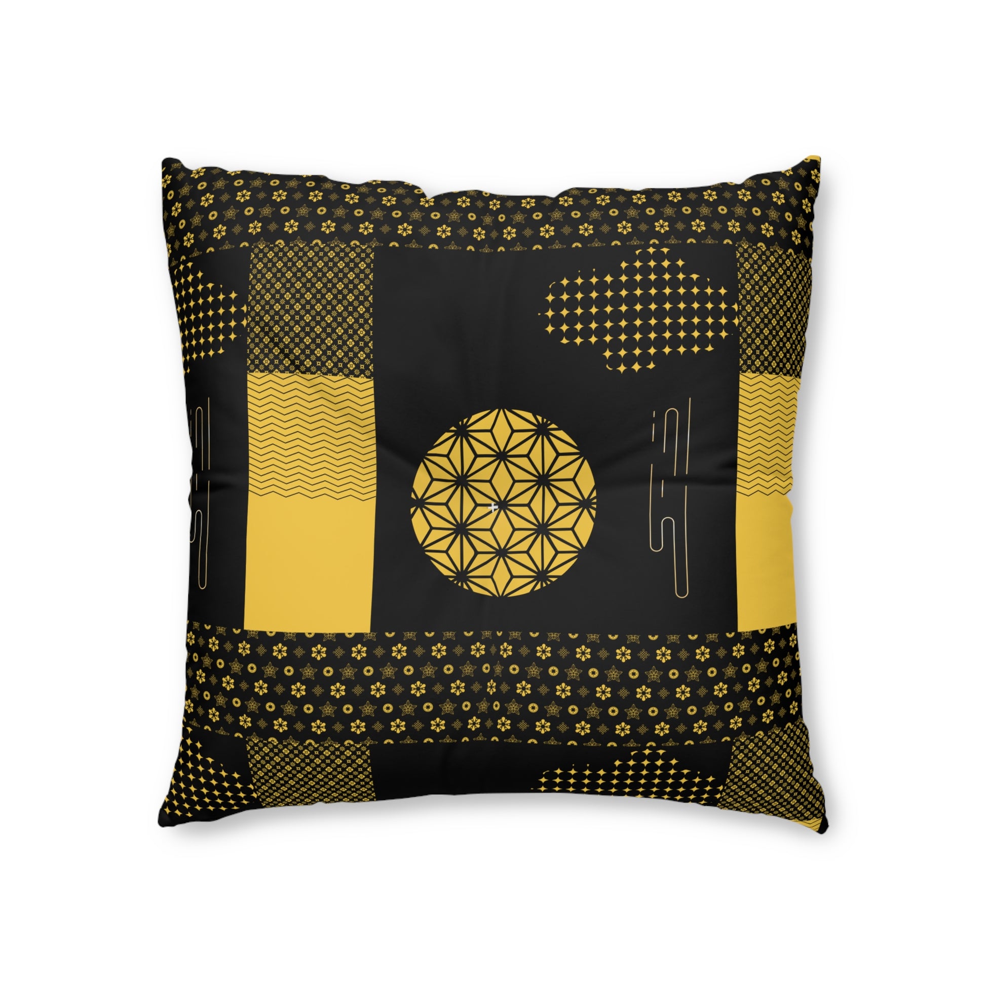 A square throw pillow featuring a black and mustard yellow geometric patchwork design with a central flower-of-life motif, shown against a plain white background.