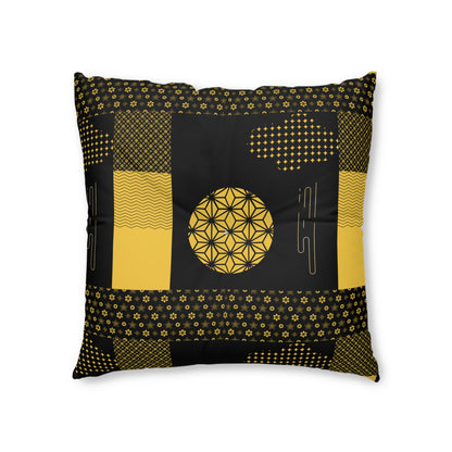 A square throw pillow featuring a black and mustard yellow geometric patchwork design with a central flower-of-life motif, shown against a plain white background.