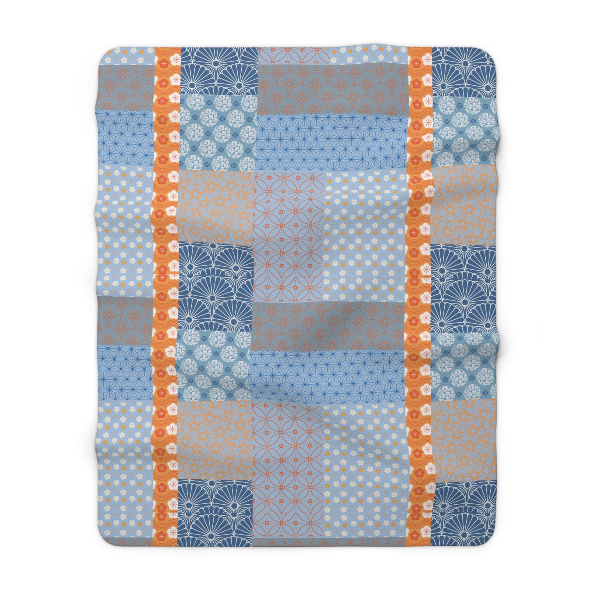 Patchwork blanket with blue, orange, and gray patterns on a white background