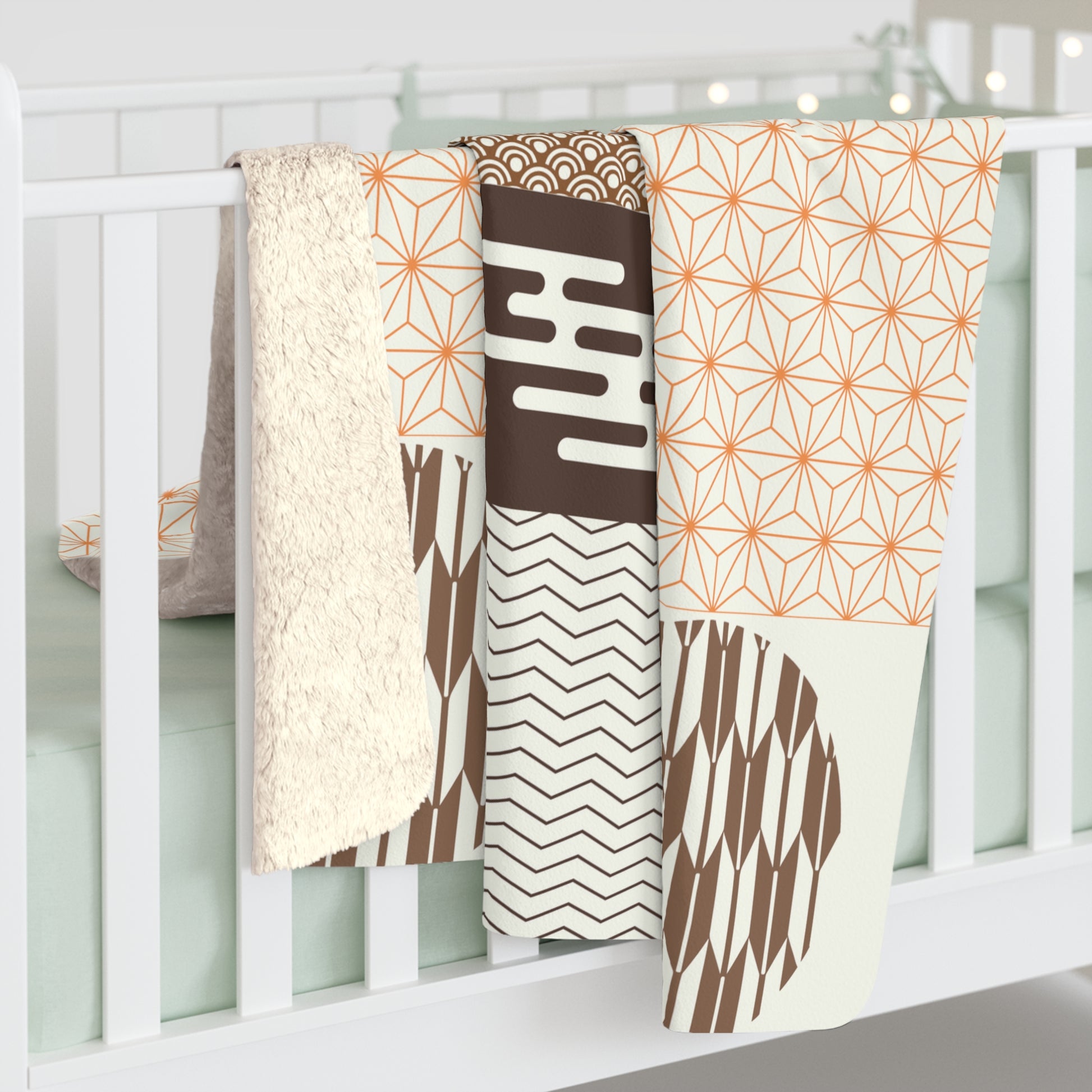 Set of patterned baby blankets hanging on a crib