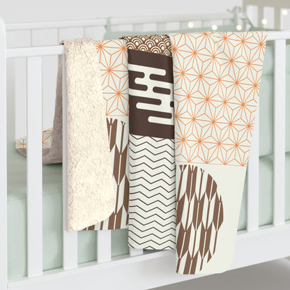 Set of patterned baby blankets hanging on a crib