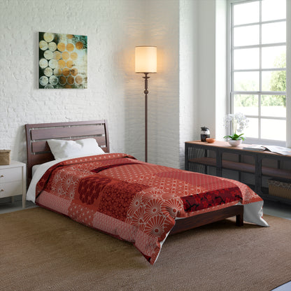 Bedroom with a bed covered in a red quilt, lamp, and artwork on the wall.