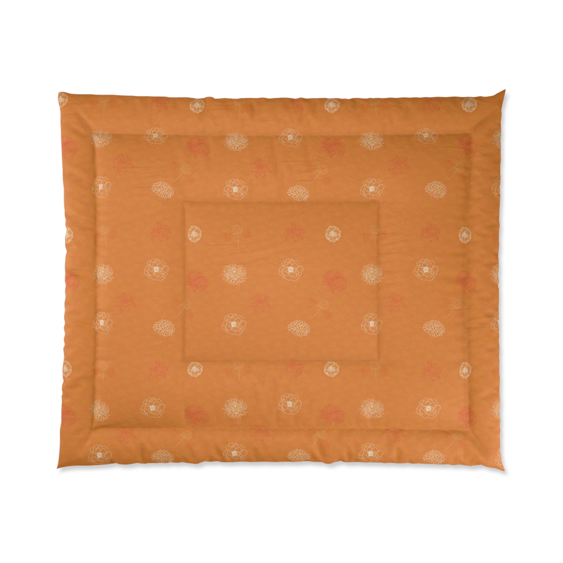 An orange quilted pet bed with a subtle pattern of small white and pink floral motifs, shown flat against a white background.