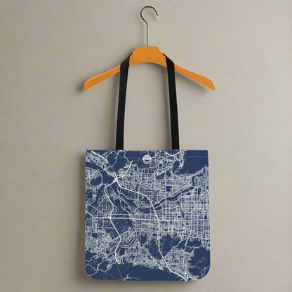 Tote bag with city map design on a hanger against a white background