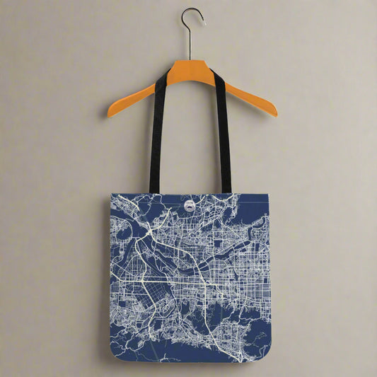 Tote bag with city map design on a hanger against a white background