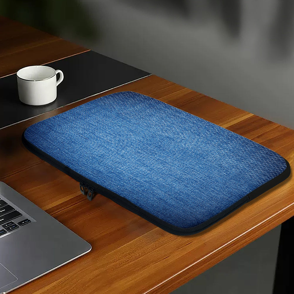 Blue laptop sleeve on a wooden desk with a laptop and mug.