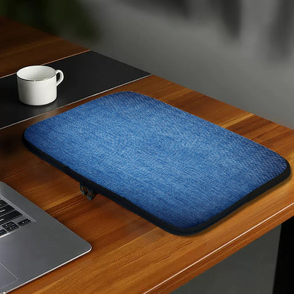 Blue laptop sleeve on a wooden desk with a laptop and mug.