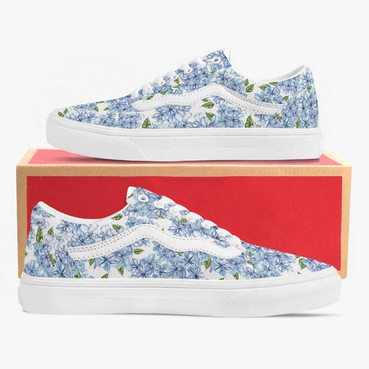 Pair of blue floral sneakers with a white sole on a red box.