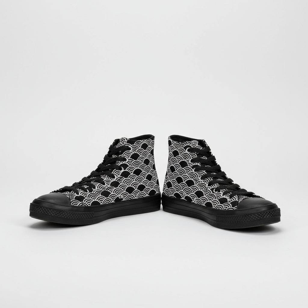 Black and white patterned high-top sneakers worn with rolled-up jeans on a white background