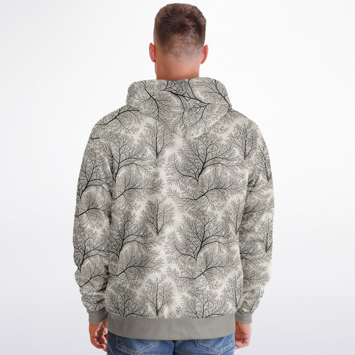 A man viewed from behind wearing a hooded sweatshirt with an all-over abstract tree branch pattern in gray and off-white, paired with blue jeans against a plain light background.