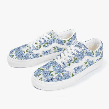 Pair of white sneakers with blue floral pattern on a white background