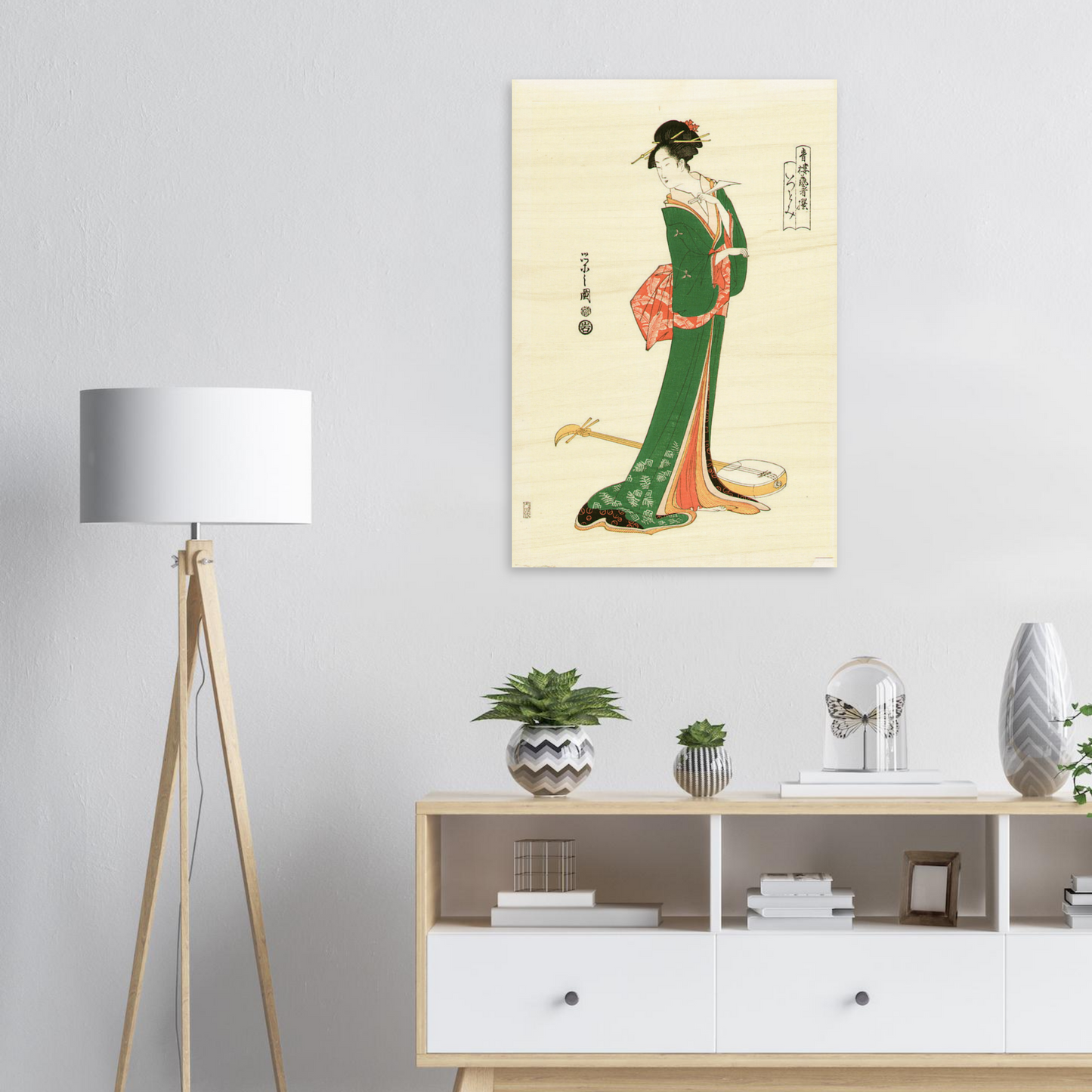 Framed artwork of a traditional Japanese figure on a wall above a white cabinet with decorative items.