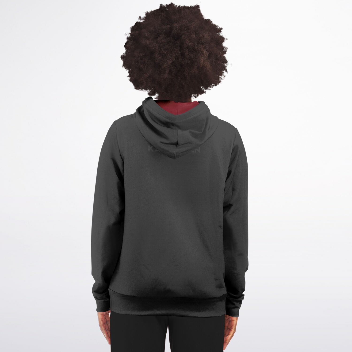 A person viewed from the back wearing a dark charcoal gray pullover hoodie with a small tonal logo on the upper back, set against a plain white studio background.