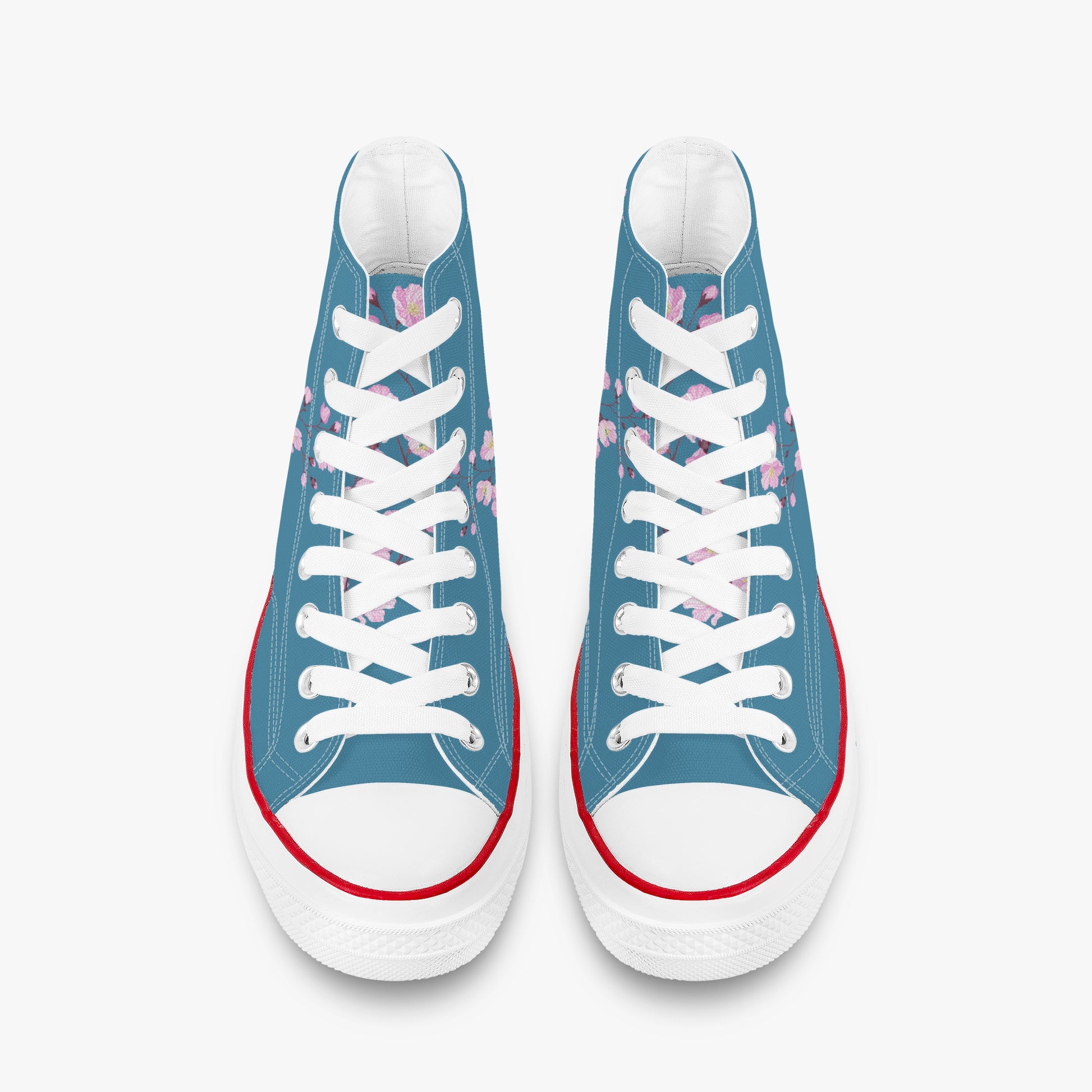 Blue sneakers with white laces and red soles on a white background