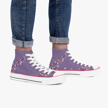 Purple high-top sneakers with floral design worn with rolled-up jeans on a white background