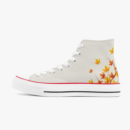 A high-top canvas sneaker in off-white, featuring a graphic print of orange and yellow autumn maple leaves on the side, white laces, a red stripe along the toe bumper, and a white rubber sole.