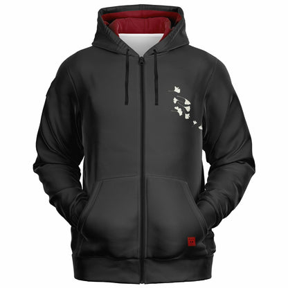 A black zip-up hoodie with a red interior hood lining, black drawstrings, a front kangaroo pocket, and a small white graphic of cats on the left chest.