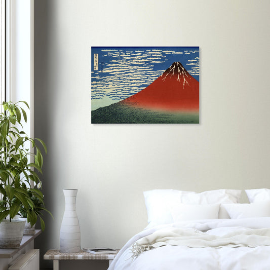 Framed artwork of a mountain on a wall above a bed in a bedroom.