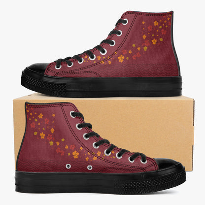 A pair of high-top canvas sneakers in burgundy with orange and yellow autumn leaf patterns, black soles, and black laces, displayed on a brown cardboard box against a light gray background.
