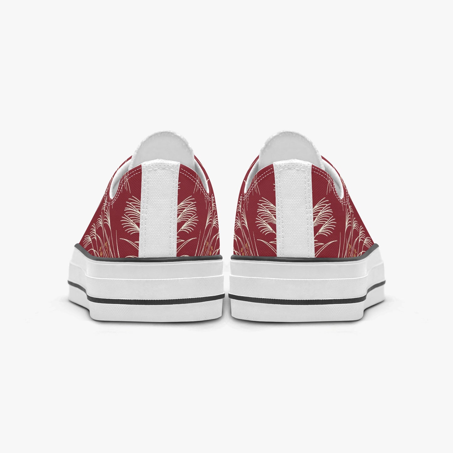 A pair of low-top canvas sneakers shown from the back, featuring a red and white palm leaf pattern on the canvas uppers, white leather side panels, and thick white platform soles with black stripes.