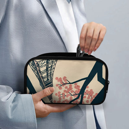 Person holding a small rectangular pouch with a design of cherry blossoms and a bridge.
