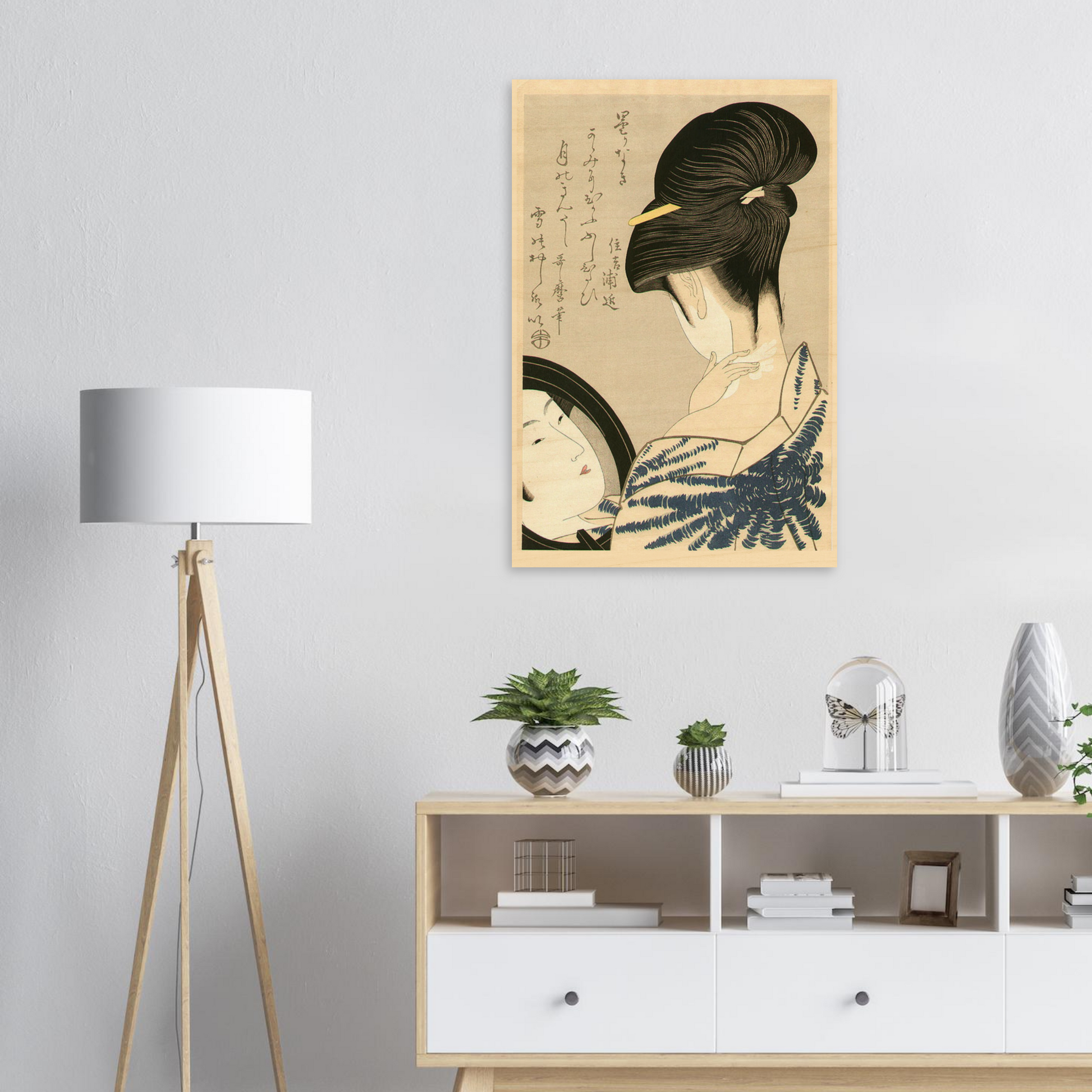 Framed artwork of a traditional Japanese geisha on a wall above a white cabinet with decorative items.