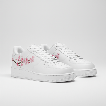 White sneakers with pink floral design on a light gray background