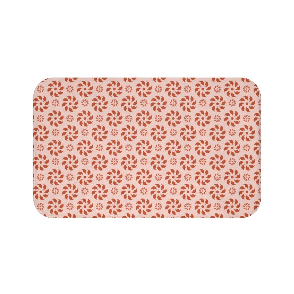 Red Spiral on Pink Background Japanese Pattern Bath Mat.   Japanese style bathmats are the perfect finishing flourish for a stylish, personality-filled bathroom, and this bath mat is as practical, as it is stylish - the anti-slip backing keeps the bath mat firmly in place and reduces the risk of slipping. 100% Microfiber. Vibrant print exit in 2 sizes 34” x 21” (86 x 53 cm) or 24” x 17” (61 x 43 cm). Anti-slip backing. Binding around the edges. Machine wash cold, gentle cycle. Tumble dry low or line dry. 