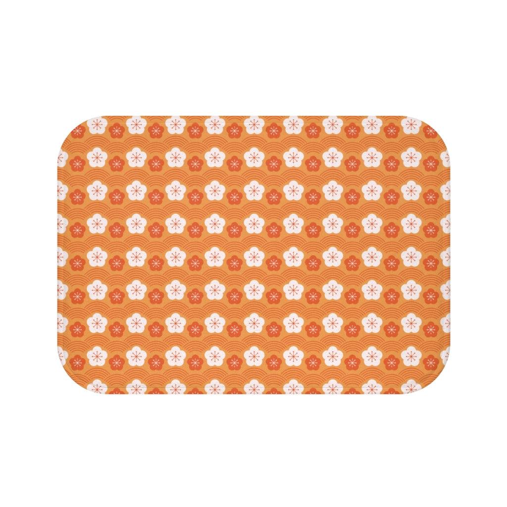 White and Dark Orange Flower Japanese Pattern Bath Mat.   Japanese style bathmats are the perfect finishing flourish for a stylish, personality-filled bathroom, and this bath mat is as practical, as it is stylish - the anti-slip backing keeps the bath mat firmly in place and reduces the risk of slipping. 100% Microfiber. Vibrant print exit in 2 sizes 34” x 21” (86 x 53 cm) or 24” x 17” (61 x 43 cm). Anti-slip backing. Binding around the edges. Machine wash cold, gentle cycle. Tumble dry low or line dry. 