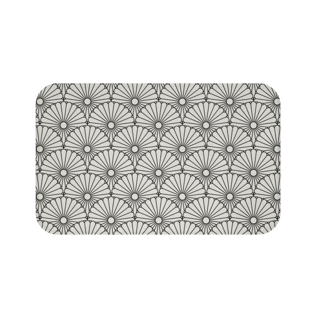 Large White Flower on Grey Japanese Pattern Bath Mat.   Japanese style bathmats are the perfect finishing flourish for a stylish, personality-filled bathroom, and this bath mat is as practical, as it is stylish - the anti-slip backing keeps the bath mat firmly in place and reduces the risk of slipping. 100% Microfiber. Vibrant print exit in 2 sizes 34” x 21” (86 x 53 cm) or 24” x 17” (61 x 43 cm). Anti-slip backing. Binding around the edges. Machine wash cold, gentle cycle. Tumble dry low or line dry. 
